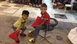 Zwei Straßenkinder freuen sich über ihre neuen Schuhe. Vor der Ankunft des Teams hat Alexandra bei den Vorbereitungen bereits viele Mützen verteilt und auch einigen Straßenkindern Schuhe gekauft.