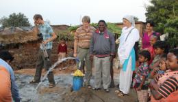 Am späten Abend, nach einer etwa 8-stündigen Bohrung wird man fündig und die Wasserfontäne spritzt uns am nächsten Tag noch entgegen. In der Mitte Michael, Jürgen, Venu und Alexandra. Am späten Abend, nach einer etwa 8-stündigen Bohrung wird man fündig und die Wasserfontäne spritzt uns am nächsten Tag noch entgegen. In der Mitte Michael, Jürgen, Venu und Alexandra.