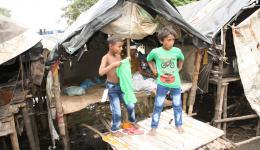 Arshad und sein kleiner Bruder ziehen stolz die neue Kleidung an… Man beachte auch die Bauweise der Hütte mit "Stelzen" zum "Schutz" vor dem Monsunregen...
