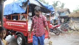 Bei strömendem Regen laden Arbeiter des Nahrungsmittelhändlers die Säcke auf den Kleintransporter.
