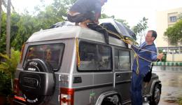 Der Taxifahrer und Guido verzurren das Gepäck und die Regenplane für die mehrstündige Fahrt nach Bhubaneswar.