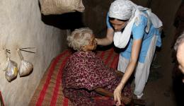 Am Abend kehren wir mit den Polstern und den Medikamenten in die „Radha Krishna“-Kolonie zurückt. Diese 100-jährige Frau ist so schwach, dass sie nur mehr auf ihrer Holzpritsche liegen kann. Einer der Liegepolster ist für sie.