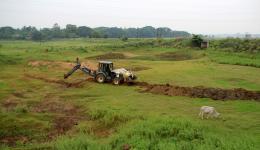 Der Bulldozer hilft beim Graben einer Seitenlinie der Wasserleitung zu den Feldern der Dörfer „zwei“ (links außerhalb des Bildes) und „vier“ (links im Hintergrund).