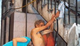 Obwohl Manuj sehr erschöpft ist und sich am nahegelegenen Geländer immer wieder festhalten muss, lächelt er, als Alexandra ihm das kalte Wasser über dem Kopf gießt. Schließlich ziehen wir ihm die neue Kleidung an und fahren zum nächsten Krankenhaus.. Obwohl Manuj sehr erschöpft ist und sich am nahegelegenen Geländer immer wieder festhalten muss, lächelt er, als Alexandra ihm das kalte Wasser über dem Kopf gießt. Schließlich ziehen wir ihm die neue Kleidung an und fahren zum nächsten Krankenhaus..