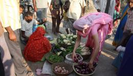Am Nachmittag fahren wir von Chakia zu einer Leprakolonie namens "Little Flower". Auf dem Weg zur zwei Stunden entfernt liegenden Kolonie halten wir an einem Markt an, um Geschenke zu kaufen. Hier wählt Alexandra Gemüse aus.