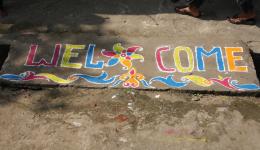 Vor dem, beim letzten Aufenthalt neu eröffneten Nähzentrum, empfängt uns ein buntes Rangoli (aus Farbpulver gestreut).