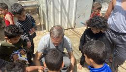 Michael verteilt in einem Flüchtlingscamp Plätzchen an die Kinder.