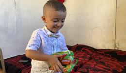 Der kleine Junge freut sich besonders über die Päckchen mit Nudelsuppe.