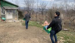 Andreas and Farhad, together with other helpers, carry the boxes to the little houses.